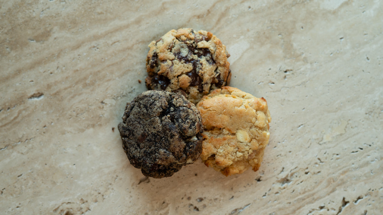 Three cookies on a textured beige surface