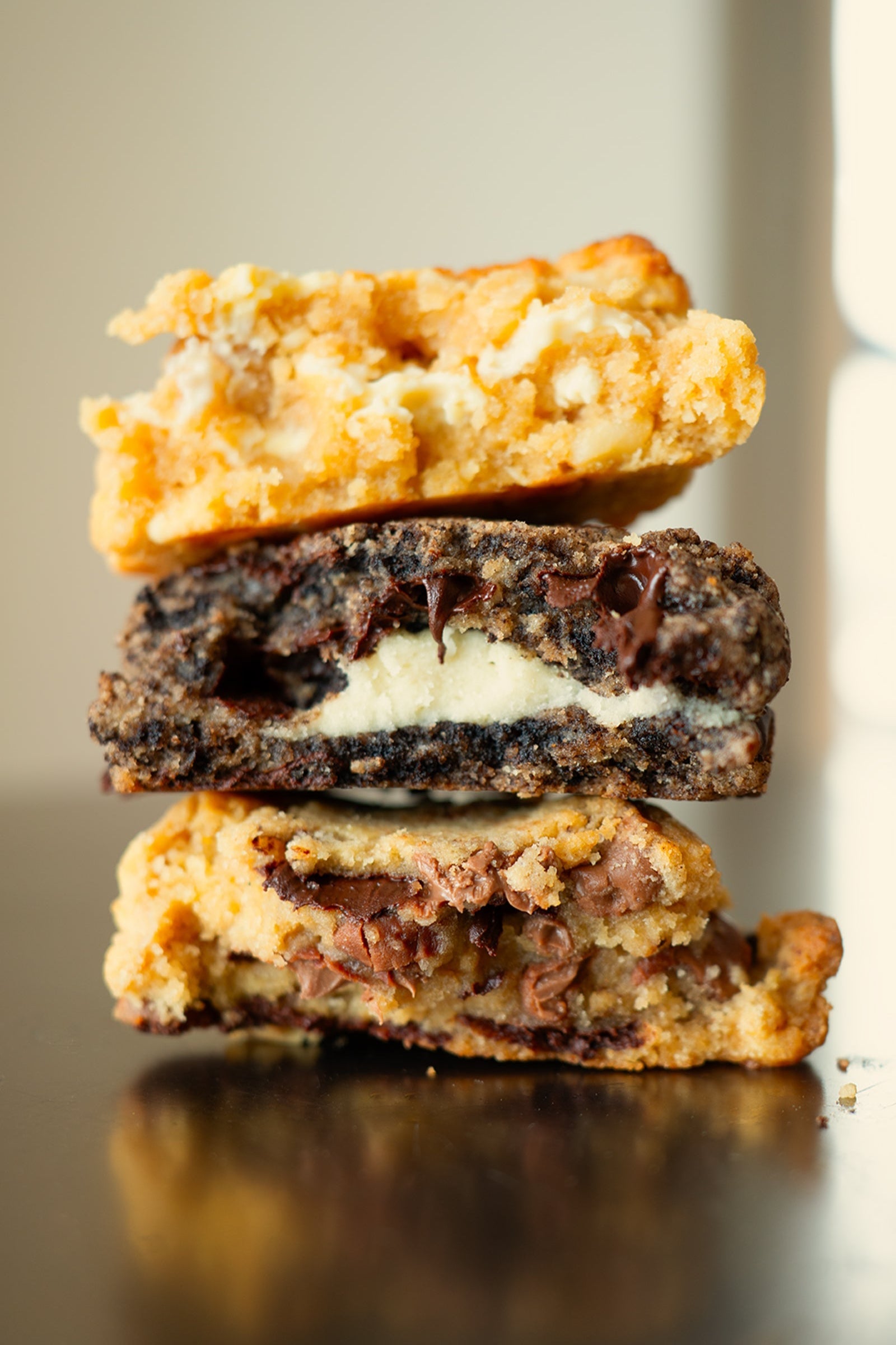 Stack of three cookie bars on a reflective surface with a neutral background