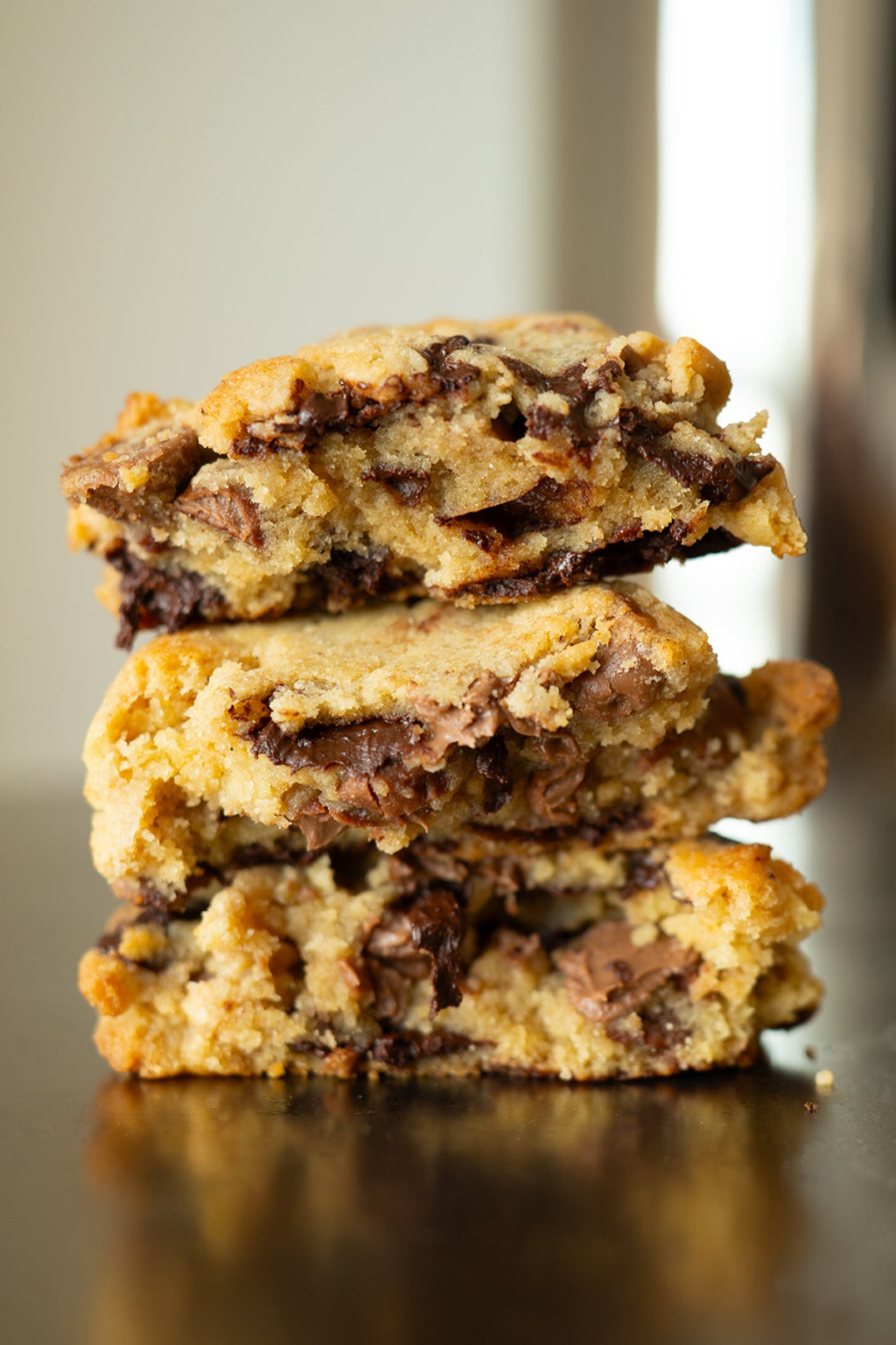 Stack of chocolate chip cookie bars on a reflective surface