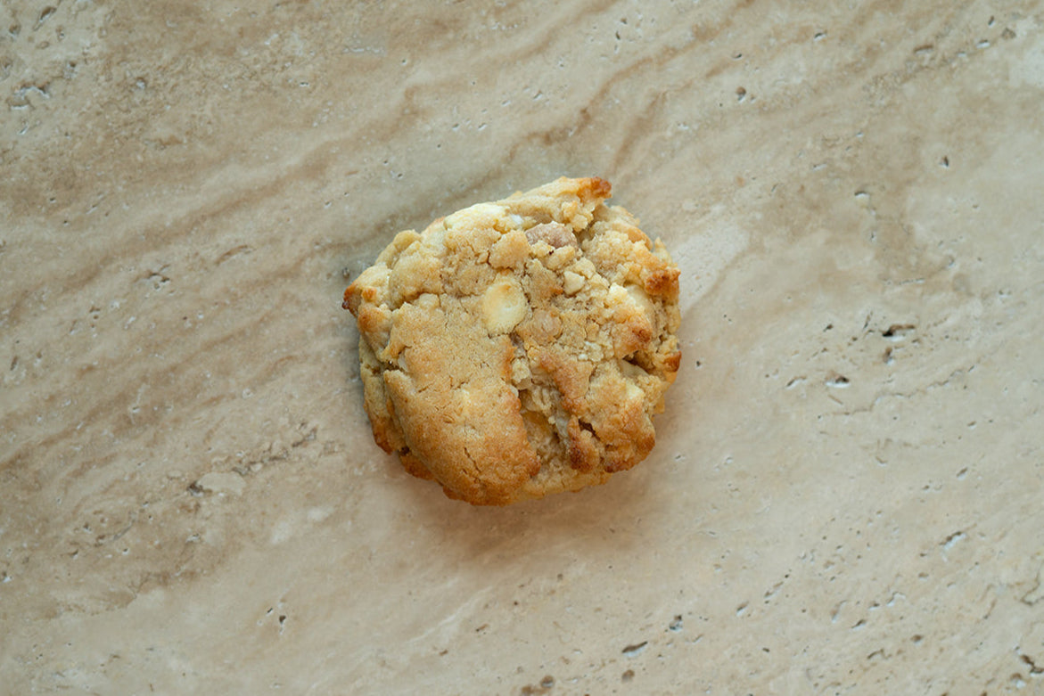 Single cookie on a beige stone surface